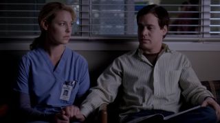 Izzie holding George's hand in the waiting room