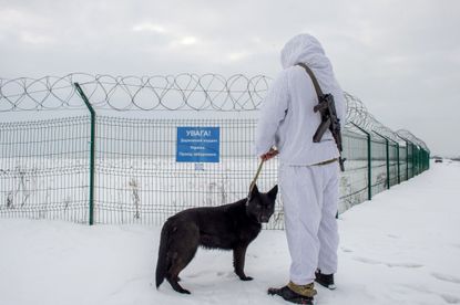 An Ukrainian frontier guard patrols along the border with Russia