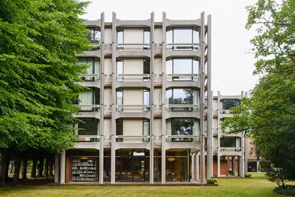 part of modern cambridge architecture, a concrete building with grass in front