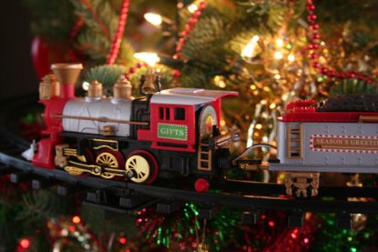 A festive train travels around the trunk of a christmas tree