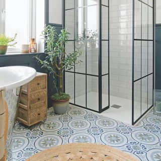 bathroom with blue tiles on the floor and glass shower enclosure