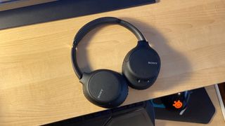 Sony WH-CH710N headphones on a wooden table