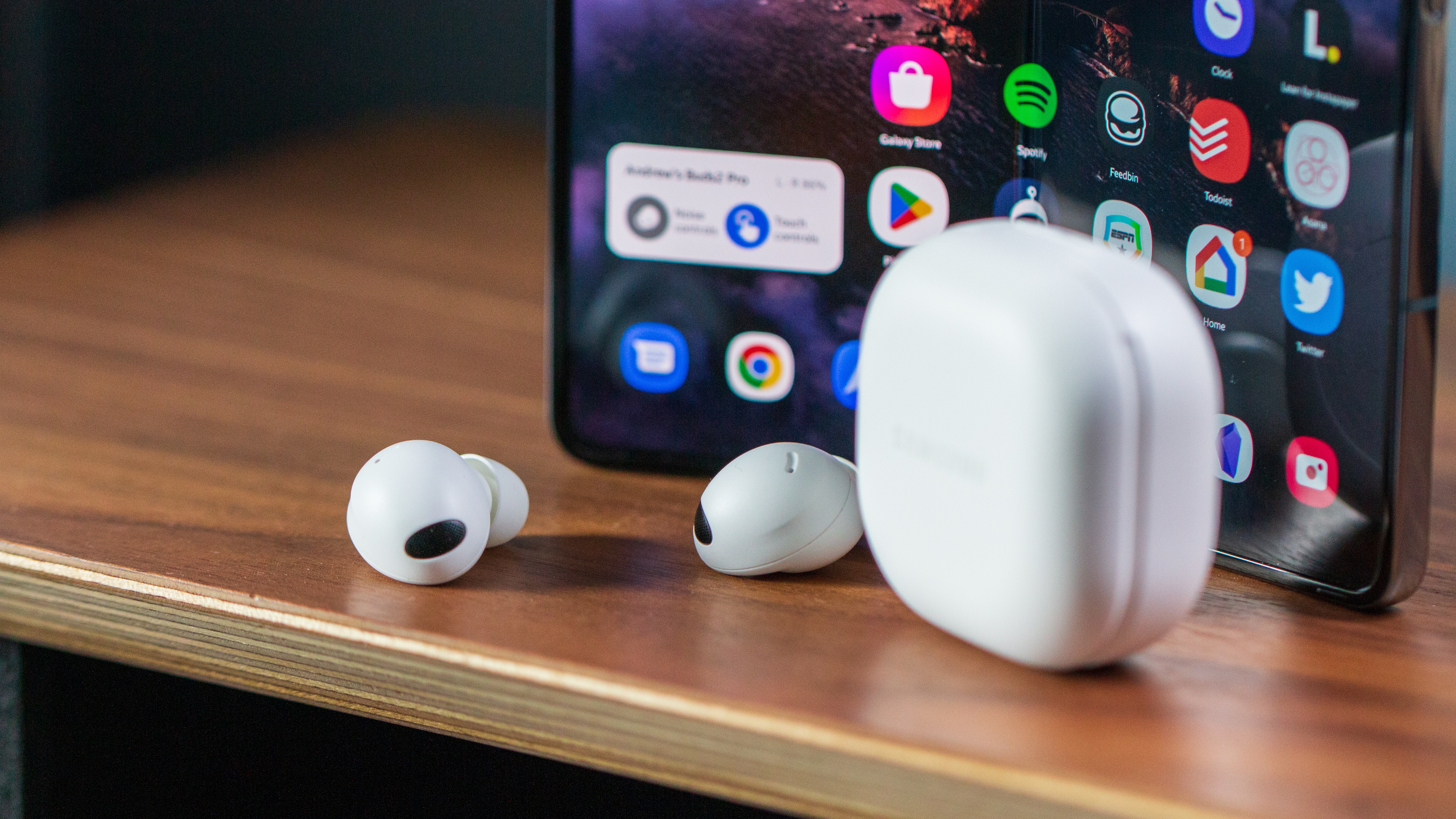 Close-up of the Samsung Galaxy Buds 2 Pro in front of the Galaxy Z Fold 4