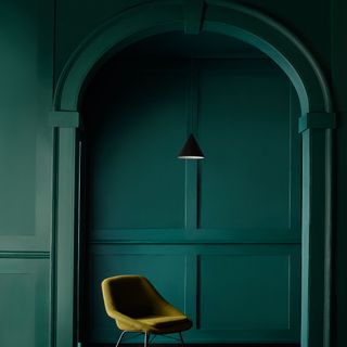 Deep blue green painted panelled hallway and archetrave