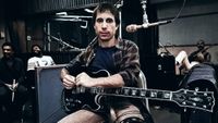 Paul Simon plays guitar during a 1980 recording session on the set of the film "One Trick Pony" in New York City Bakithi Kumalo