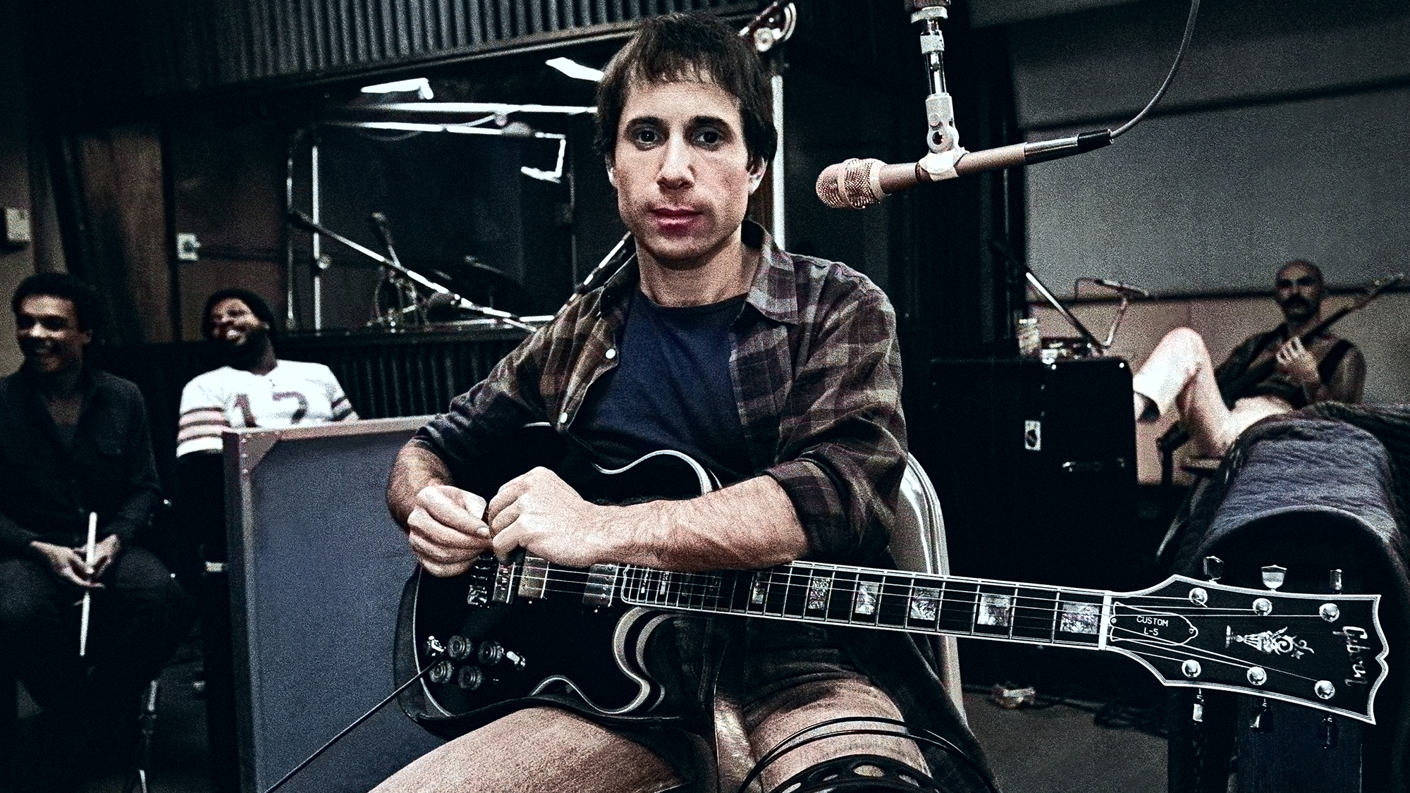 Paul Simon plays guitar during a 1980 recording session on the set of the film "One Trick Pony" in New York City Bakithi Kumalo