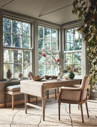 home office with view to garden, extendable desk, armchair, bench, rug, vases and ornaments