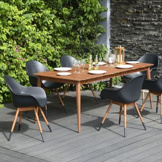 wooden table and black chairs near garden