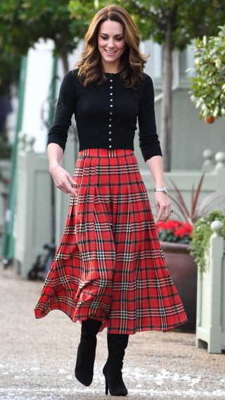 Catherine, Princess of Wales laughs as a machine sprays snow ahead of her hosting a Christmas party in 2018