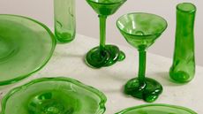 close up of vivid green glass table setting with champagne coupes, plates and vases