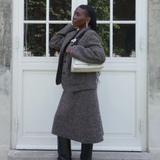 Influencer @daniellejinadu wears black wedge boots with a grey knitted two-piece.