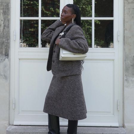 Influencer @daniellejinadu wears black wedge boots with a grey knitted two-piece.