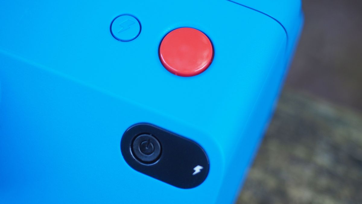 Blue Polaroid Go Gen 2 camera, on a wooden surface in a woodland setting