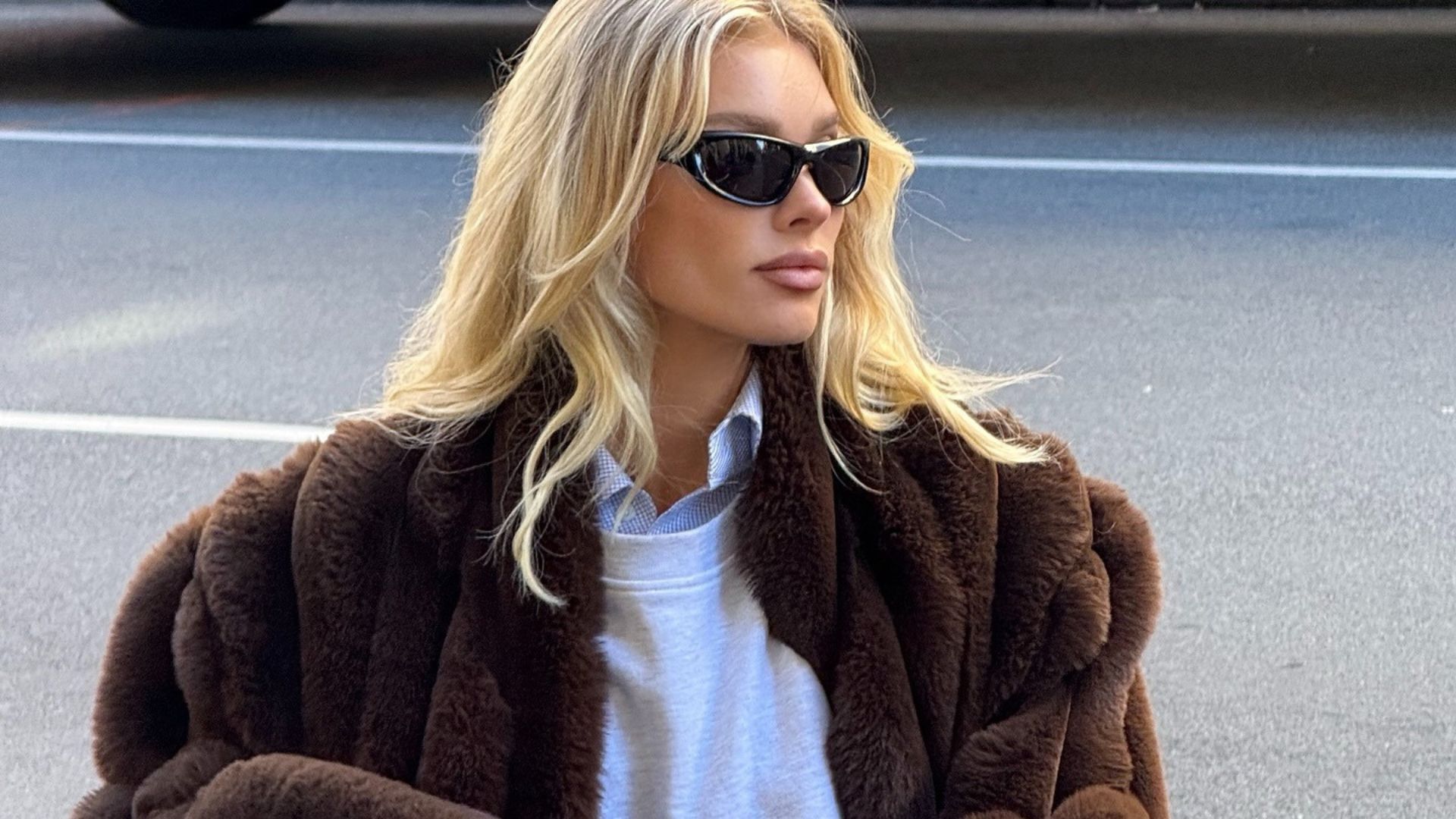 Elsa Hosk wears beige cord trousers with a fur-trimmed coat and a white zip-up hoodie.