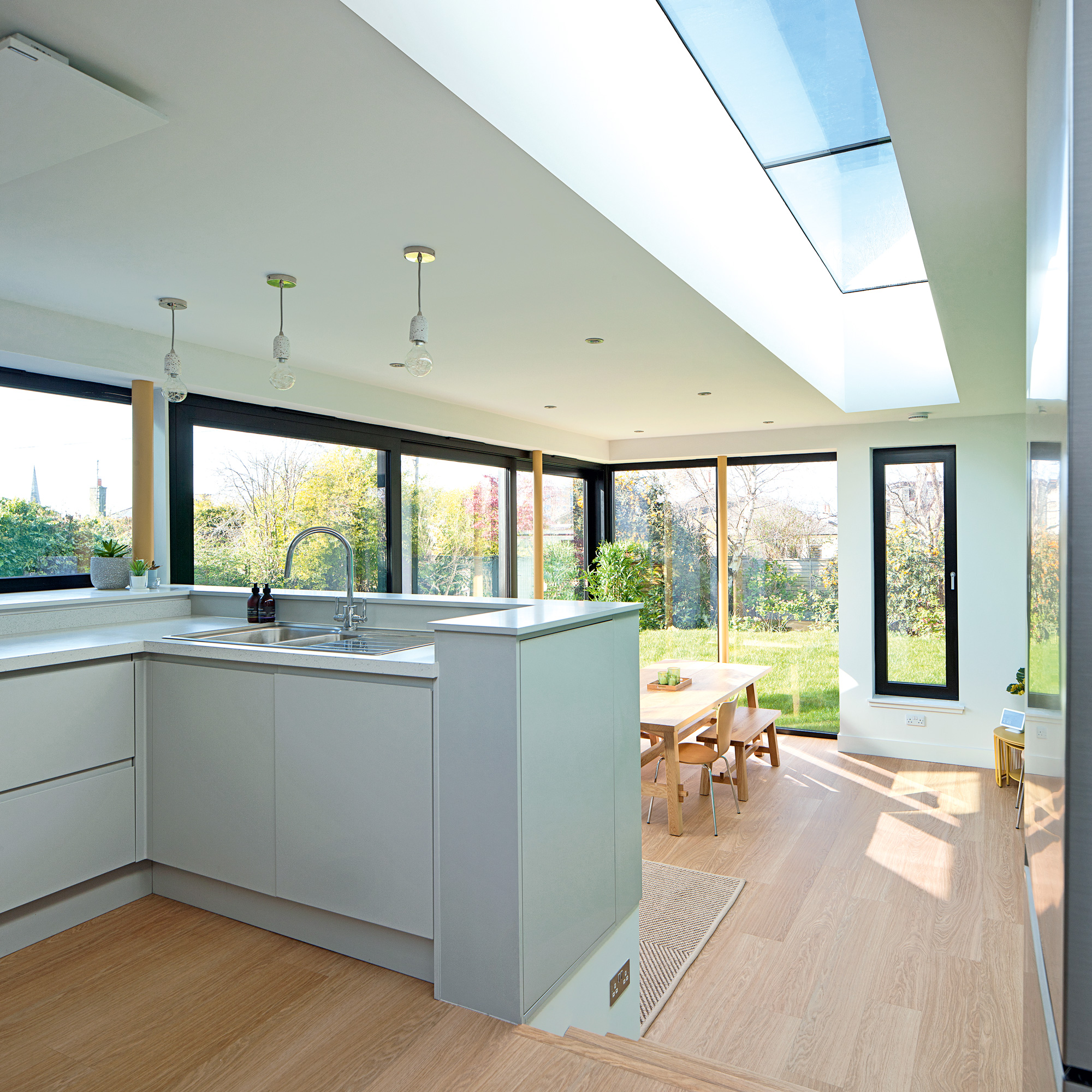 open plan space showing the kitchen and dining area and wrap around glazing with a view into the garden
