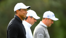 Tiger Woods walks down the fairway with various golfers