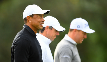 Tiger Woods walks down the fairway with various golfers