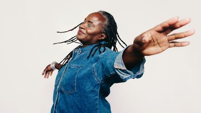 An older woman appears to flying with her arms spread.