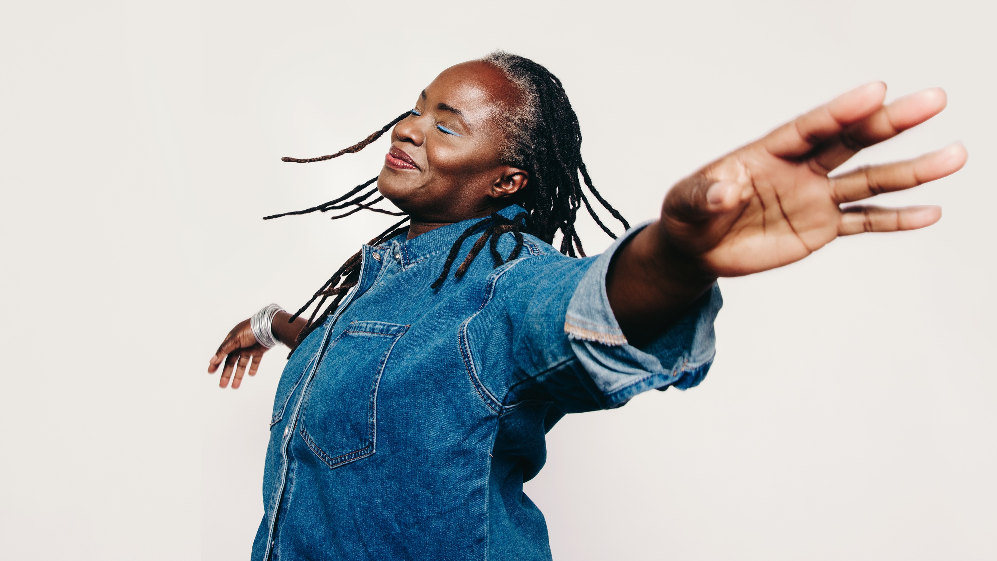 An older woman appears to flying with her arms spread.