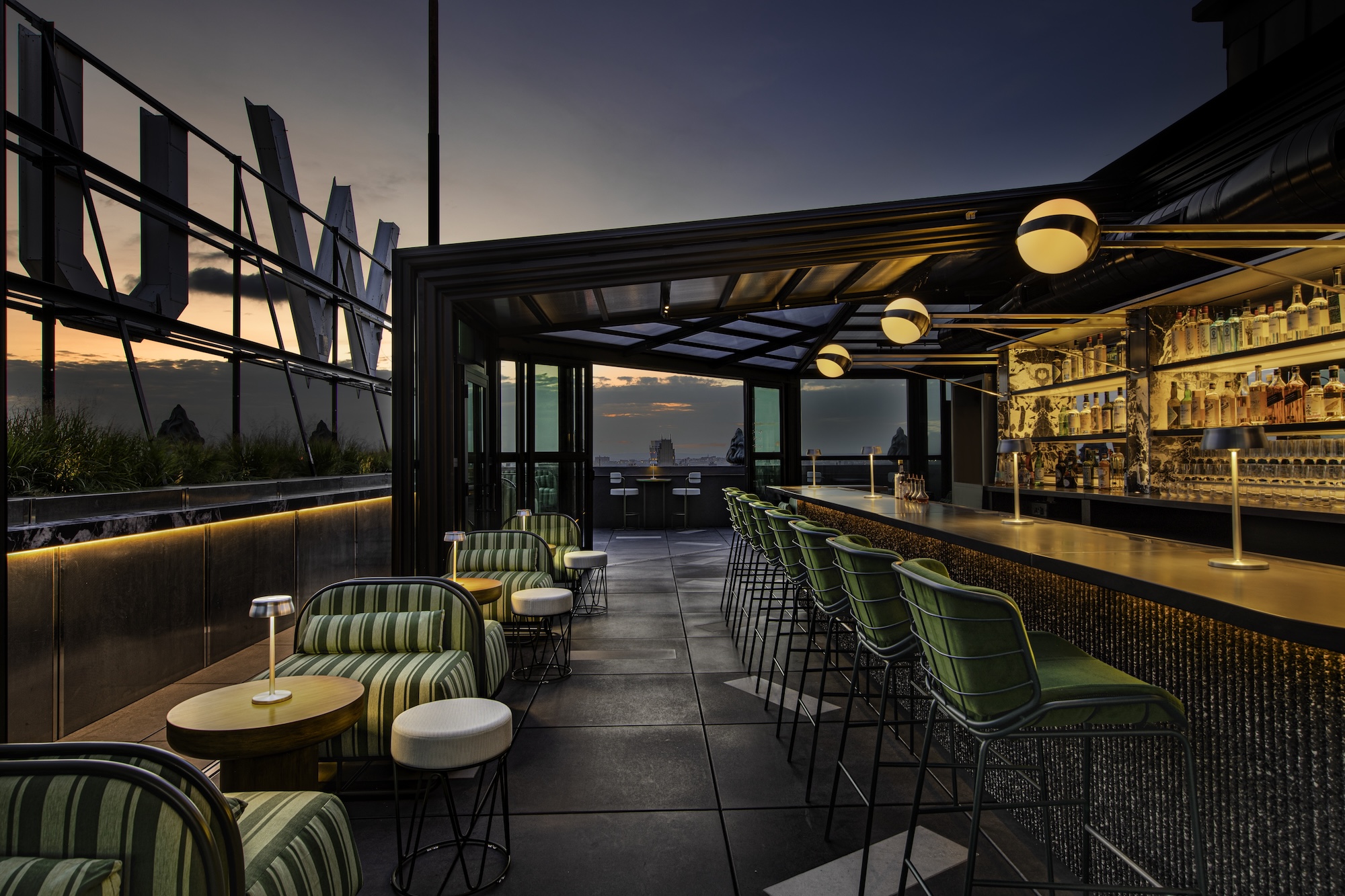 a view of the rooftop at w new york union square with striped chairs and outline of neon roof sign