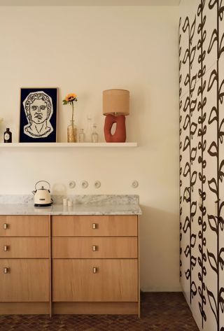 a wood kitchen with a patterned wallpaper