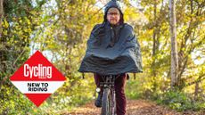 Sam Jones rides a commuter bike wearing a waterproof poncho