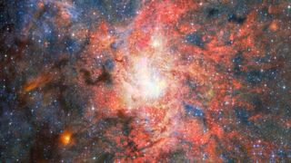 This image features data from Webb&rsquo;s MIRI (Mid Infrared Instrument) to capture the most detailed mid-infrared view yet of the field that hosts the highly evolved star IRS 3, which is located just 0.55 light-years from Sagittarius A*, the Milky Way galaxy's central supermassive black hole.&nbsp; An international team of astronomers have discovered that dust and water can form and survive surprisingly close to this supermassive black hole. The observations reveal that the evolved star IRS 3 continues to enrich its surroundings with newly formed material despite the intense radiation environment around Sagittarius A*. [Image description: A bright, densely populated star cluster lies near the centre of the image, surrounded by intricate clouds of glowing gas and dust in shades of red, pink, orange, and blue. Dark lanes of dust weave through the nebula, contrasting with the luminous central region. Countless stars are scattered across the field, with a few brighter foreground stars showing Webb's characteristic diffraction spikes. An irregular black region occupies the lower-right corner of the image, indicating an area where no observational data was available.]
