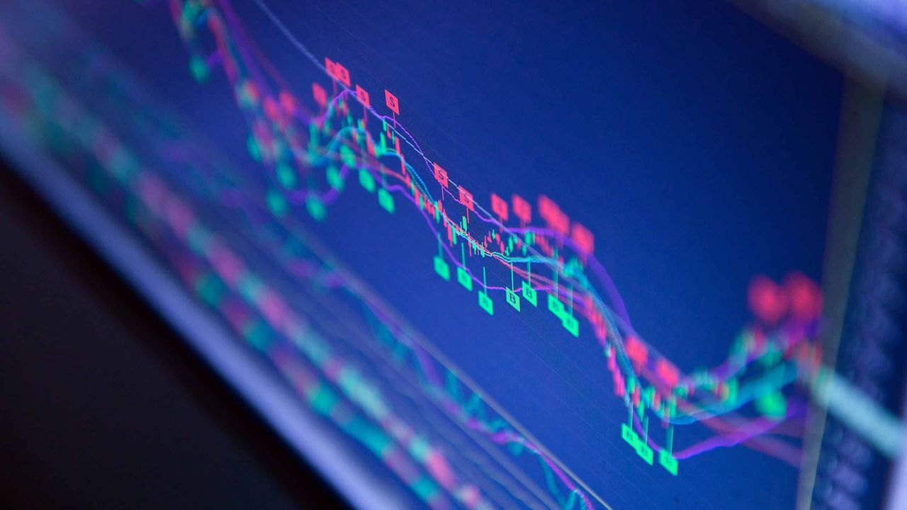 closeup of blue stock market chart with red and green bars on laptop