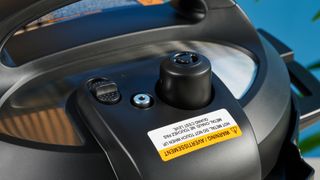 a black pressure cooker photographed against a blue background, showing its cooking presets, steam release valve, and Instant Pot branding