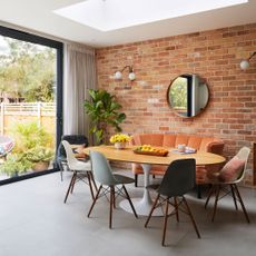 Dining room with exposed brick wall along back of room with dining table and chairs in front