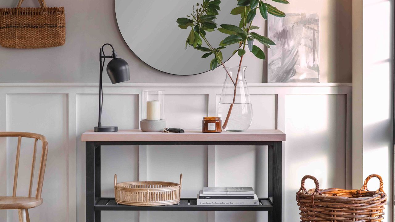 hallway decorating mistakes a hallway with a console table and round mirror above alongside a storage basket