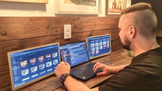 Working on the Siaviala S6 Laptop Screen Extender with a laptop up against a wall in a coffee shop