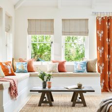 White living room with orange curtains and lobsters