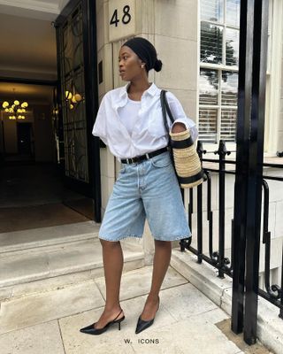 An influencer wearing relaxed denim shorts and a white shirt.