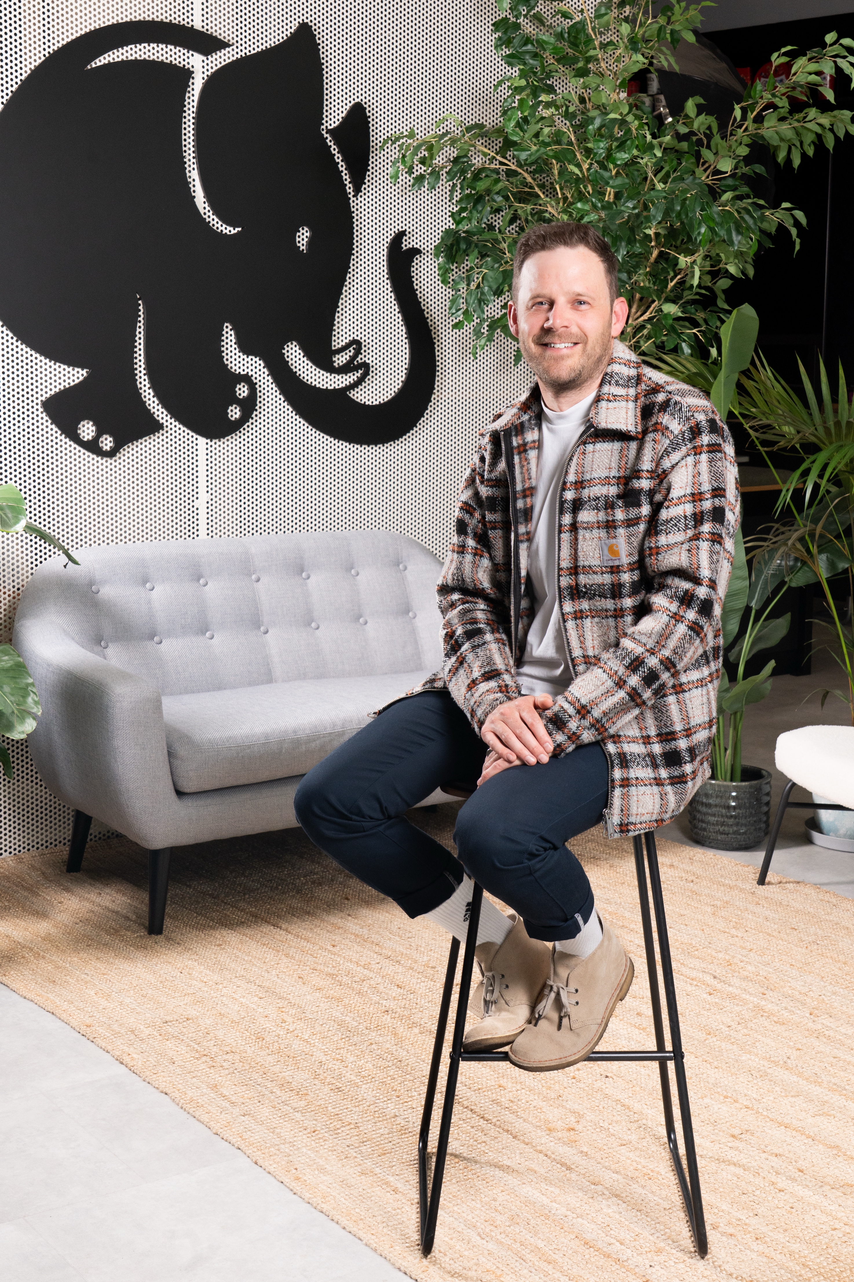 Taxi Studio's Jamie Watson sitting on a stool