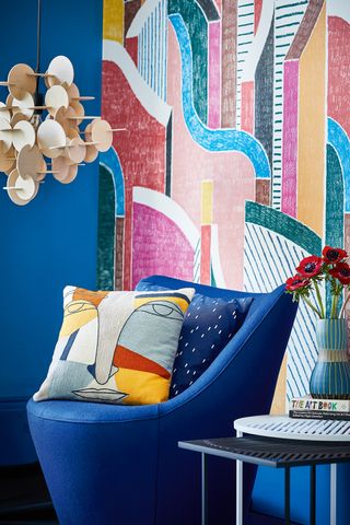 blue living room chair with patterned wall in digital colors