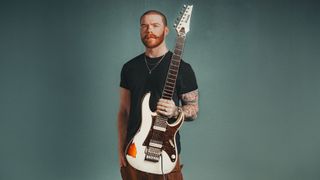 Clayton King poses with a custom Ibanez RG model