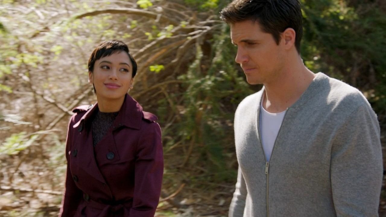 Andy Allo and Robbie Amell talking and walking in Upload.