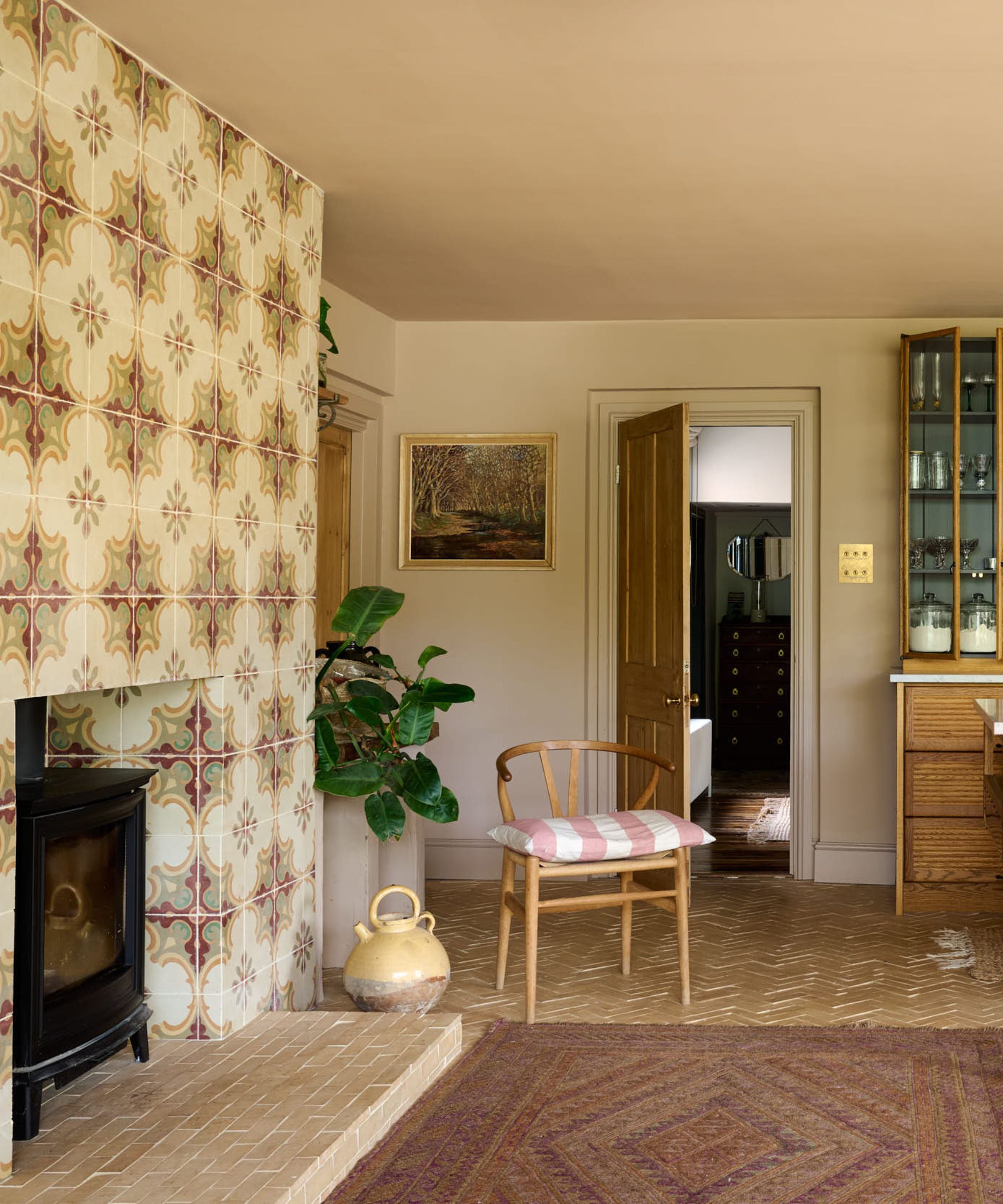 The corner of a Mediterranean style kitchen with a tiled fireplace wall and a warm neutral hue on the walls