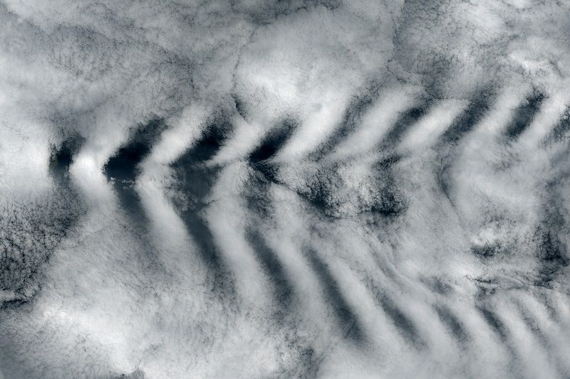 The tall peaks of Amsterdam Island interrupted air currents passing by and created cloud &quot;waves.&quot;