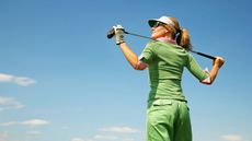 Female golfer looking up to the sun