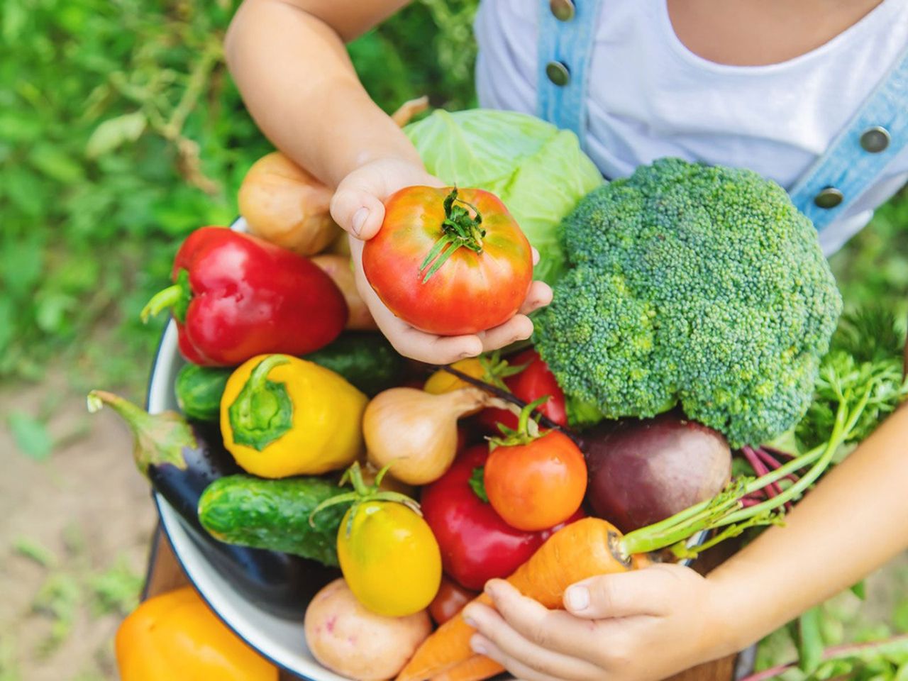 Child Holding A Large Bowl Of Fresh Vegetables