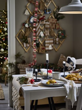 A festive dining table dressed for Christmas and breakfast with an alternative christmas tree hanging on the wall in the background