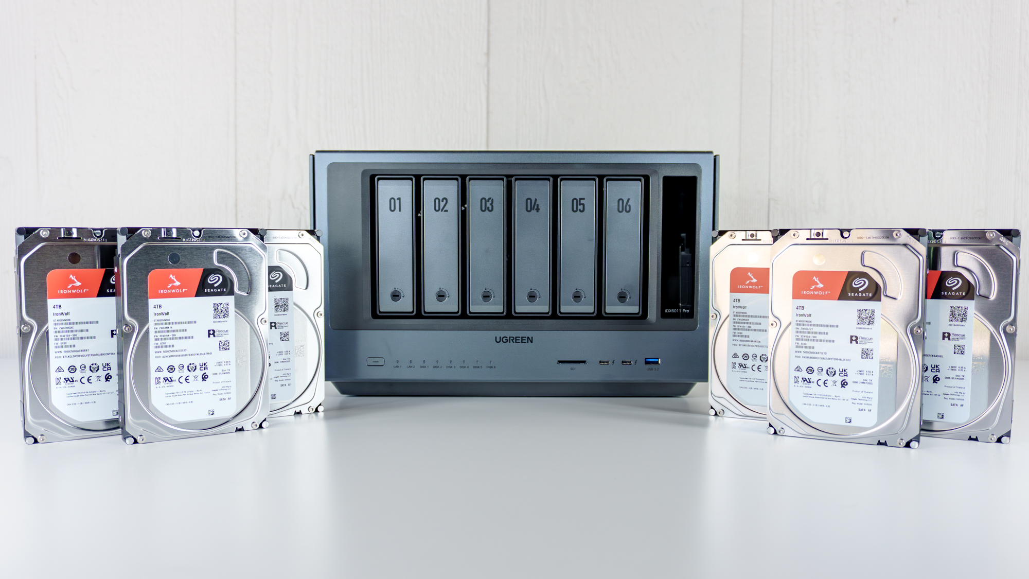 The Ugreen iDX6011 Pro NAS on a table with six hard drives