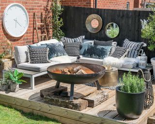 outdoor living zone on deck with fire pit and sofa