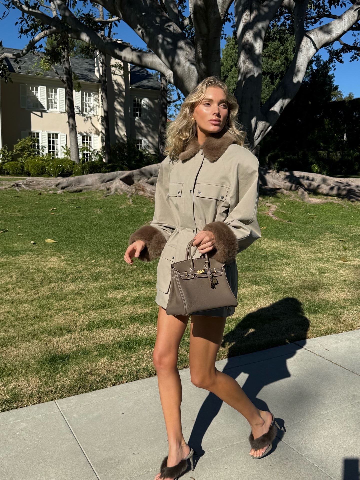 Elsa Hosk in a taupe jacket and faux-fur sandals.