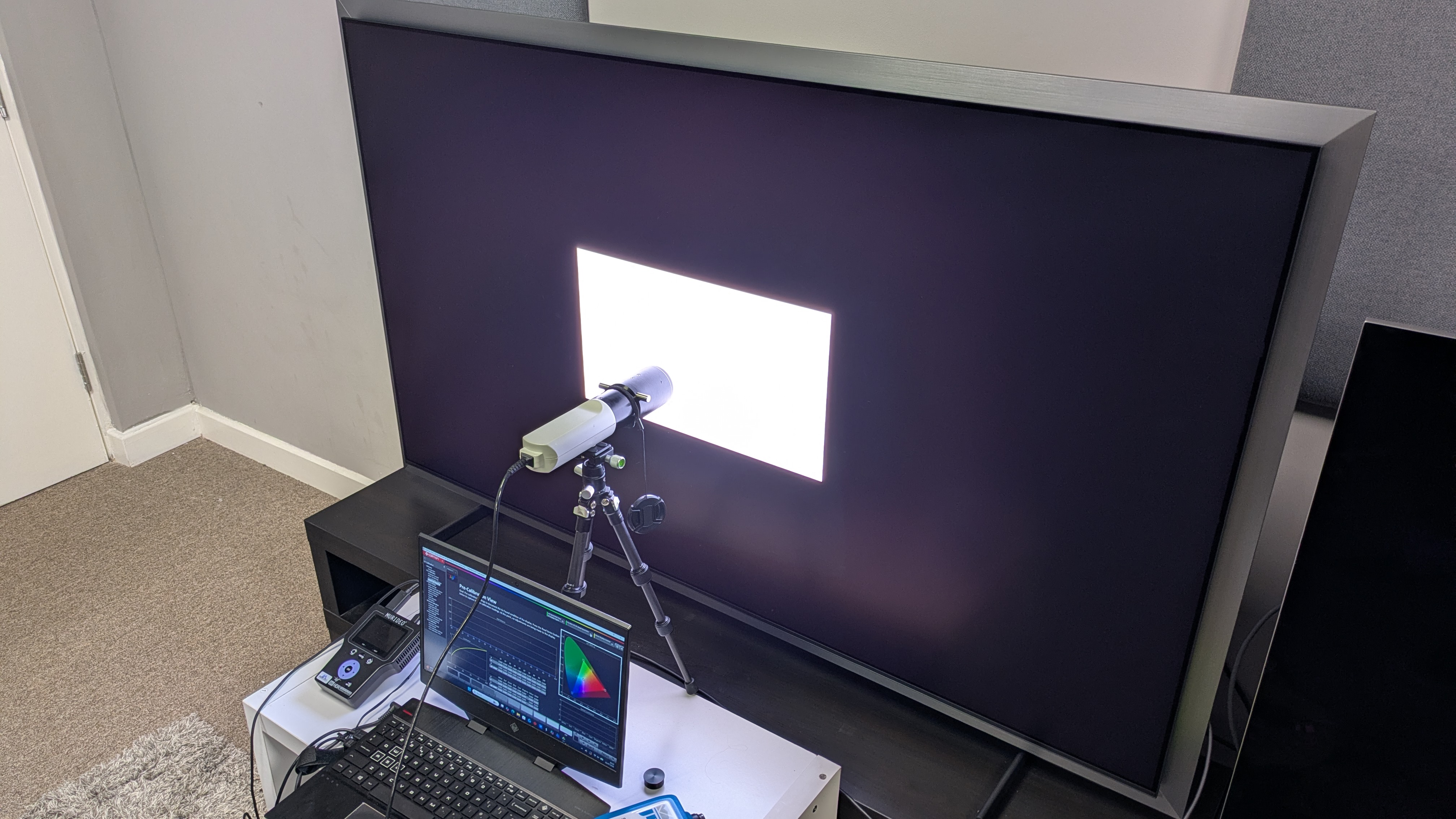 Samsung S99H with testing equipment attached and white window pattern on screen