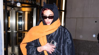 Dua Lipa wearing an oversized scarf with a black hoodie and a Hermes Birkin bag 