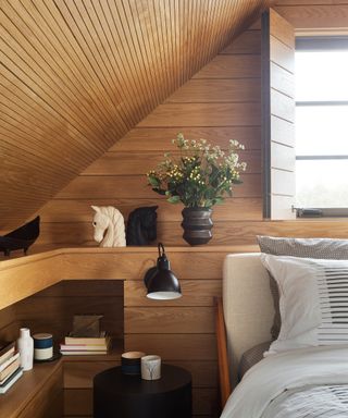 Small bedroom storage ideas in a wooden room with sloped ceiling.