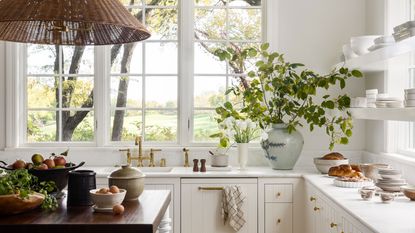 a white kitchen with shelves across the window